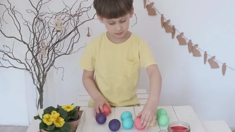 Preparing for the Easter holiday. Boy playing with Easter eggs Stock Footage 147950944