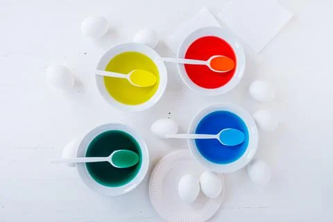 Preparing for Easter. White eggs with liquid food coloring. Different colors in Stock Photos