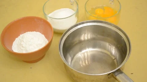 Preparing egg sponge - pouring eggs into saucepan and beating up Stock Footage 45820559