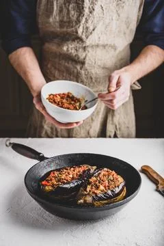 Preparing eggplants stuffed with ground beef, tomatoes and spices Stock Photos
