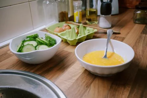 Preparing eggs for breakfast in home kitchen. Stock Photos