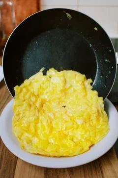 Preparing eggs for breakfast in home kitchen. Stock Photos