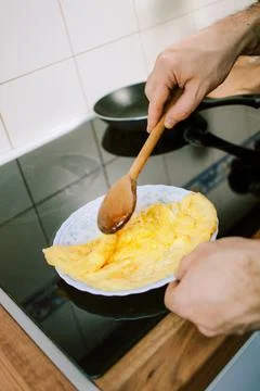 Preparing eggs for breakfast. Overhead view of black kitchen stove  Stock Photos