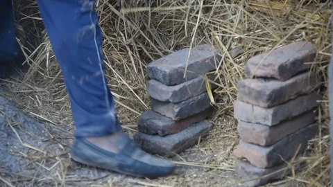 Preparing a fire ceramic pots by laying brick and hay - Bhaktapur Nepal Stock Footage 79838893