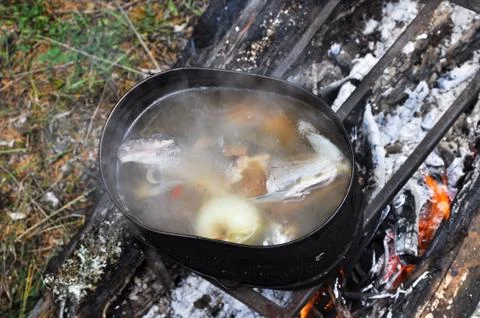 Preparing fish soup on the fire during the trip. Stock Photos