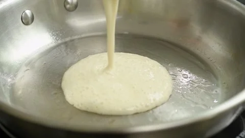 Preparing of fluffy Moroccan pancake. The cook pours mixture in the frying pan. Stock Footage 240376783