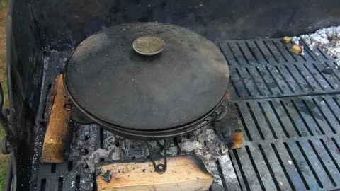 Preparing food in pot on grid. Smoke rise from coal. Handheld slow motion Stock Footage 115776562