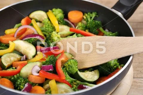 Preparing food vegetables in cooking pan with spatula Stock Photos