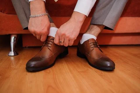 Preparing for a Formal Event: A Man Tying His Brown Dress Shoes Stock Photos