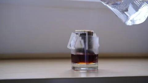 Preparing fresh brewed drip coffee in glass cup with trendy paper drip coffee Stock Footage 251457268