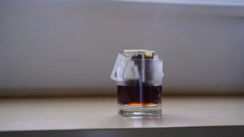 Preparing fresh brewed drip coffee in glass cup with trendy paper drip coffee Stock Footage 252872427