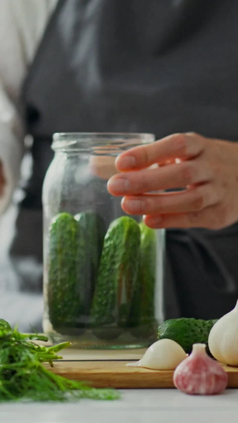 Preparing fresh cucumbers for pickling in a kitchen during afternoon hours Stock Footage 331721293