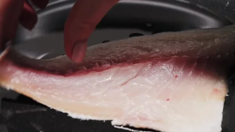 Preparing fresh fish fillet in a hot pan with oil to make a delicious meal Stock Footage 314379763