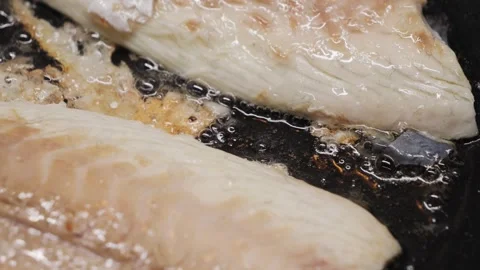 Preparing fresh fish fillet in a hot pan with oil to make a delicious meal Stock Footage 316305950