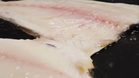 Preparing fresh fish fillet in a hot pan with oil to make a delicious meal Stock Footage 316689617