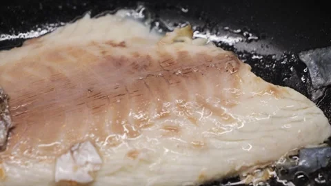 Preparing fresh fish fillet in a hot pan with oil to make a delicious meal Stock Footage 316689701