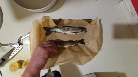 Preparing fresh fish with lemons on a kitchen countertop Stock Footage 296498287