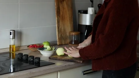 Preparing fresh ingredients in a cozy kitchen setting Stock Footage 299231143