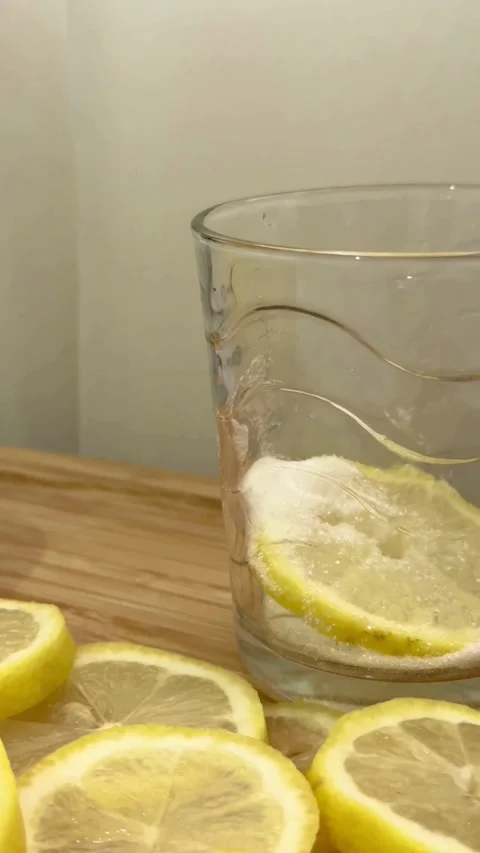 Preparing fresh lemonade by adding lemon slices and sugar Stock Footage 331975978