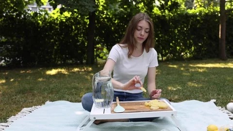 Preparing fresh lemonade with lemons on a sunny day in the backyard garden Stock Footage 297369215