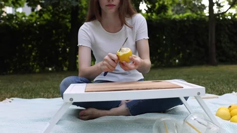 Preparing fresh lemonade outdoors with a focus on simplicity and enjoyment Stock Footage 297370661