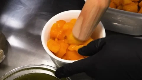 Preparing Fresh Mango Chunks in a White Bowl in a Commercial Kitchen Stock Footage 331632648