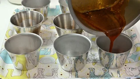 Preparing fried sugar in bowls to make flan Stock Footage 219716922