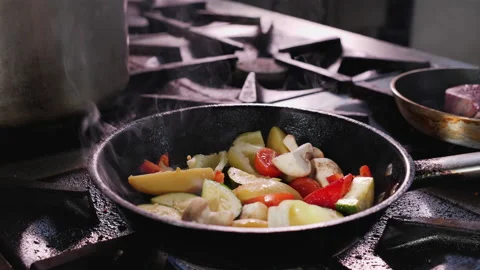 Preparing fried vegetables, tossing the pan - close up Video stock 152607965