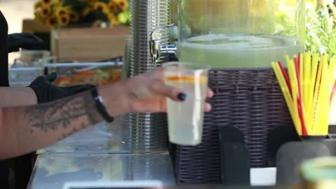 Preparing a glass of lemonade, selling fresh cold lemonade at public event Stock Footage 136032045
