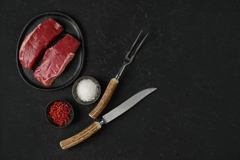 Preparing gourmet beef steak dinner with fresh ingredients on a dark textur.. 库存照片