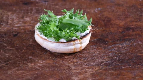 Preparing gourmet burger, adding meat patty Stock Footage 205122520