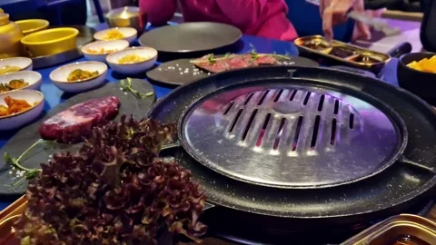 Preparing the grill for cooking meat in a restaurant, the waitress adds water Stock Footage 262967227