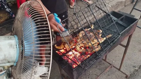 Preparing grilled chicken barbeque (BBQ) on charcoal.vendor flipping and fanning Stockbeeldmateriaal 238917224