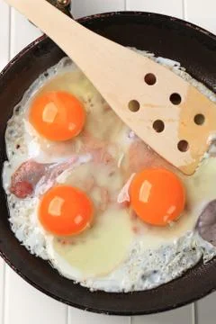 Preparing ham and eggs in a frying pan Stock Photos