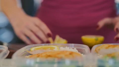 Preparing healthy lunch containers with chicken and lemon slices in the kitch Stock Footage 310244152