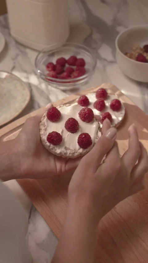 Preparing Healthy Rice Cake Snack with Cream Cheese and Fresh Raspberries Stock Footage 344016784