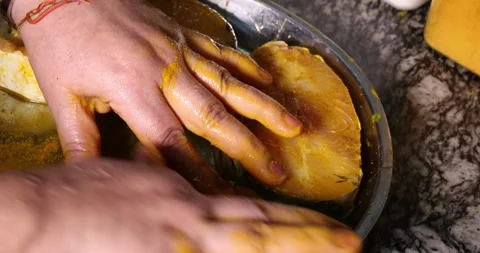 Preparing hilsa fish cut pieces for Asian Bengali cooking frying rubbing me.. Stock Footage 275003599