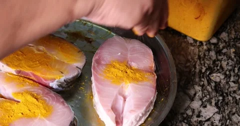 Preparing hilsa fish cut pieces for Asian Bengali cooking frying rubbing me.. Stock Footage 275003601