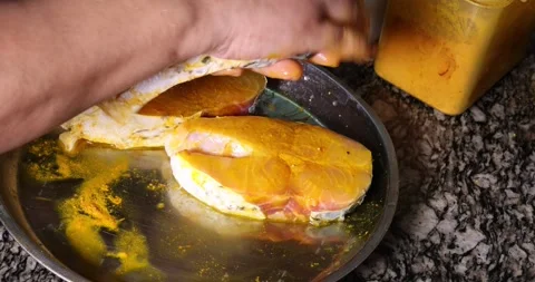 Preparing hilsa fish cut pieces for Asian Bengali cooking frying rubbing me.. Stock Footage 275003609