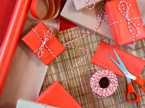 Preparing for the holiday - gift wrapping in red and beige wrapping paper Stock Photos