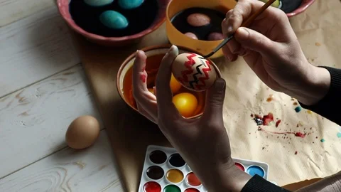Preparing for the holiday. A woman paints a Easter egg with traditional patterns Stock Footage 125437053