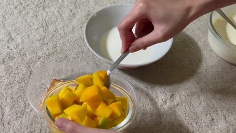 Preparing homemade cheesecuit dessert topped with fresh mango slices Stock Footage 327242539