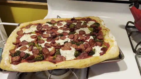 Preparing homemade pizza with broccoli and sausage in the kitchen Stock Footage 326351404