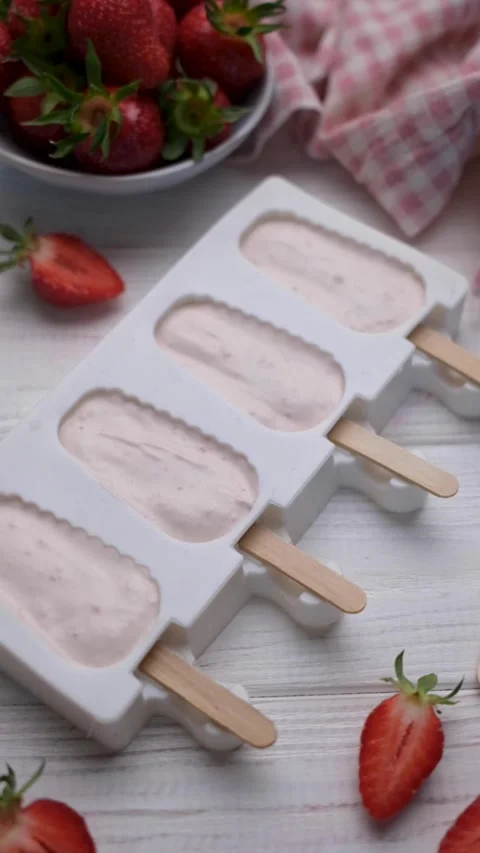 Preparing homemade strawberry popsicles for freezing Stock Footage 336809282