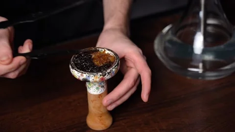 Preparing hookah. Step by step. The hookah man clogs tobacco in hookah bar. Stock Footage 153217157