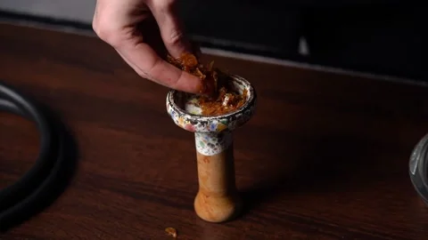 Preparing hookah. Step by step. The hookah man clogs tobacco in hookah bar. Stock Footage 153217184