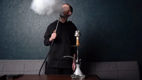Preparing hookah. Step by step. Hookah man lights hookah and blows smoke. Stock Footage 153217369