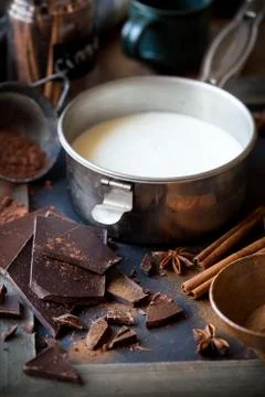 Preparing hot chocolate - a small pan of milk, cocoa powder, dark chocolate Stock Photos