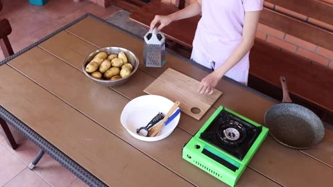 Preparing ingredients for a cooking session outdoors on a wooden table Stock Footage 297358393