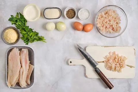 Preparing ingredients for a meal featuring fish and other foods in a kitche.. Fotos de archivo